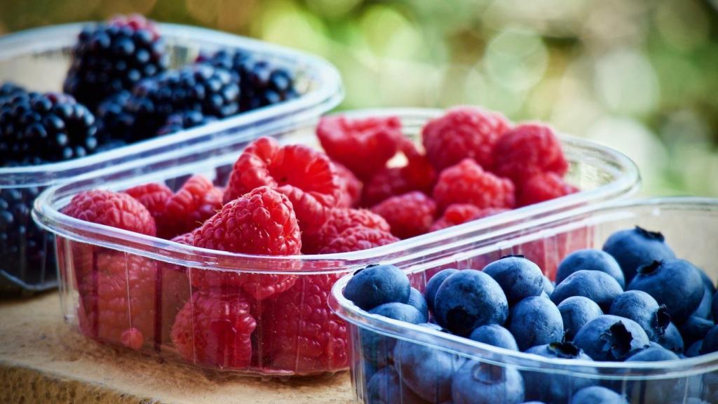 Moras, frambuesas y arándanos en envases de plástico.