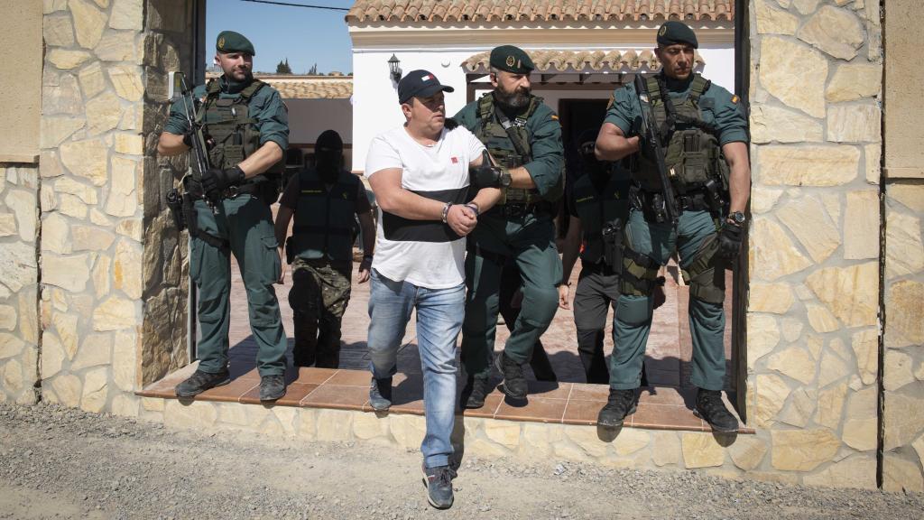 Instante en el que la Guardia Civil traslada a uno de los detenidos en Trebujena (Cádiz) tras la Operación Doberman