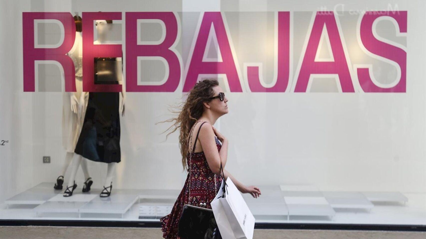 Una mujer pasea frente a un cartel de rebajas en una imagen de archivo.