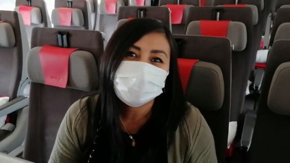 Una pasajera en un avión con mascarilla.