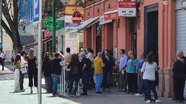 Varias personas beben en la puerta del bar denunciado.