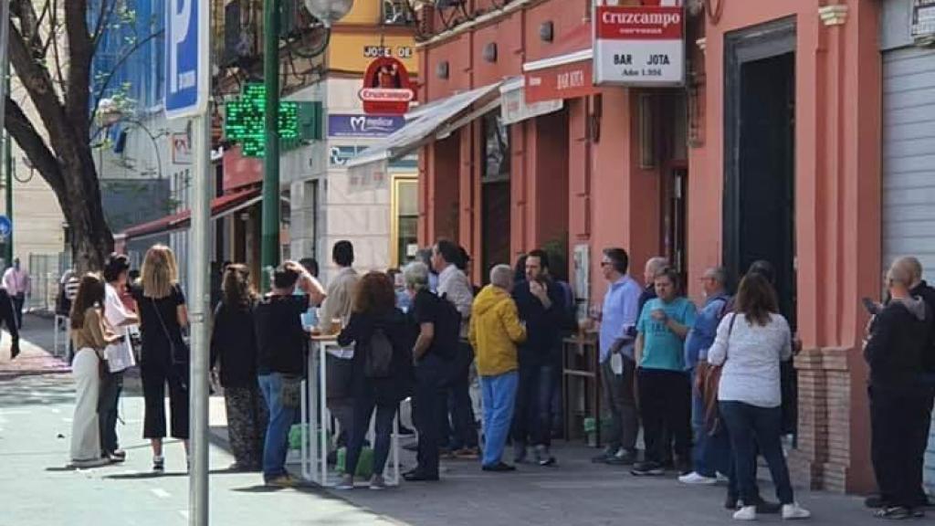 Varias personas beben en la puerta del bar Jota.