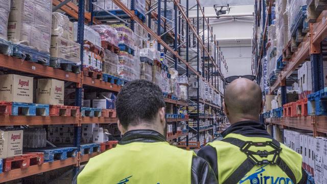 Dos operarios de Airvant con uno de sus drones en un almacén de mercancías.