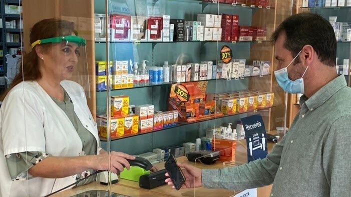 Una farmacéutica, junto a un ciudadano, en Córdoba.