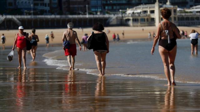 Paseo por la playa de La Concha de San Sebastián manteniendo la distancia de seguridad. EFE/Juan Herrero.