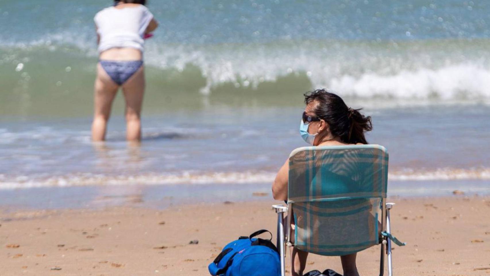Una mujer con mascarilla en la playa de San Fernando, en Cádiz.