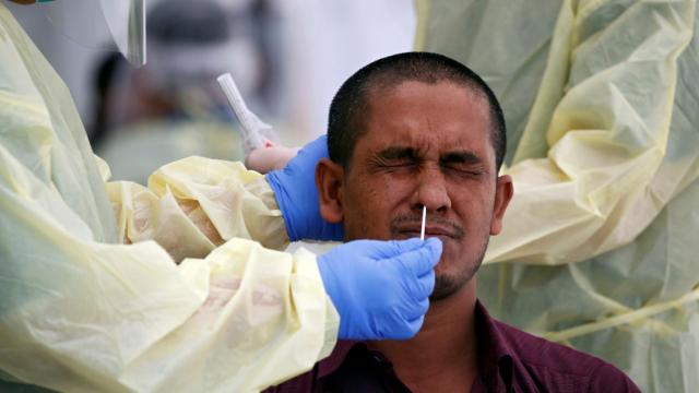 Sanitarios haciendo el test de covid-19 a un emigrante que trabaja en Singapur.