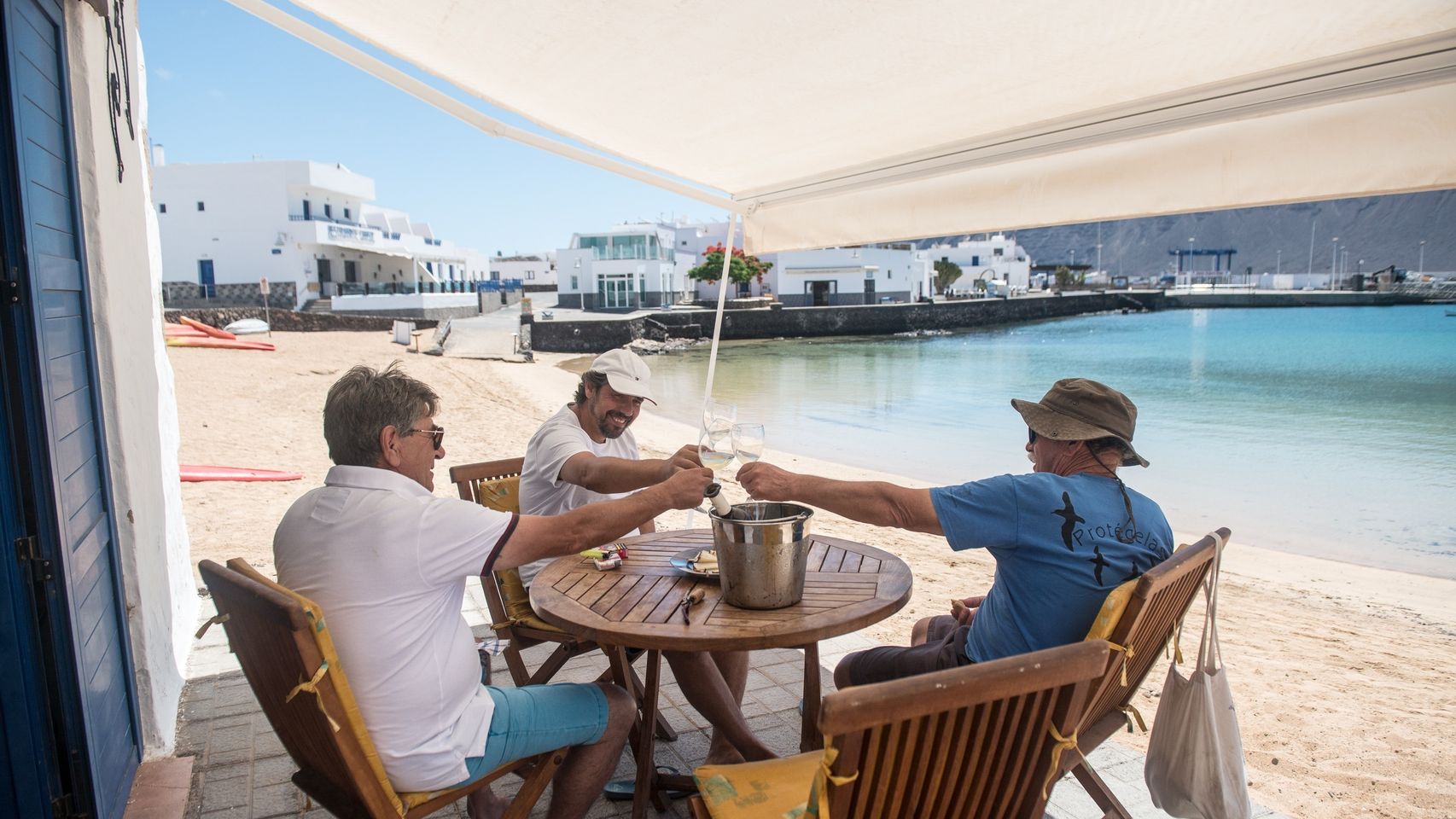 Unos hombres celebran el paso a la fase III en La Graciosa.