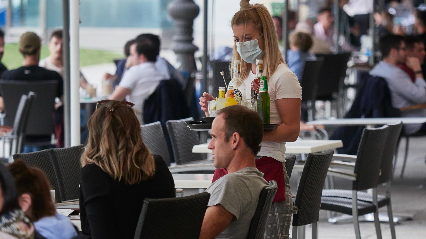 Una trabajadora atiende a los clientes de una terraza en la famosa Plaza del Castillo de Pamplona.