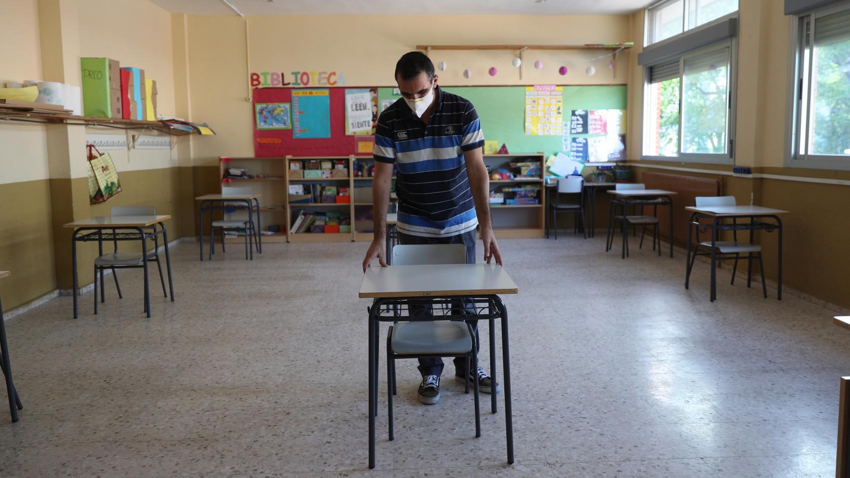 Un profesor prepara la llegada de los alumnos al colegio.