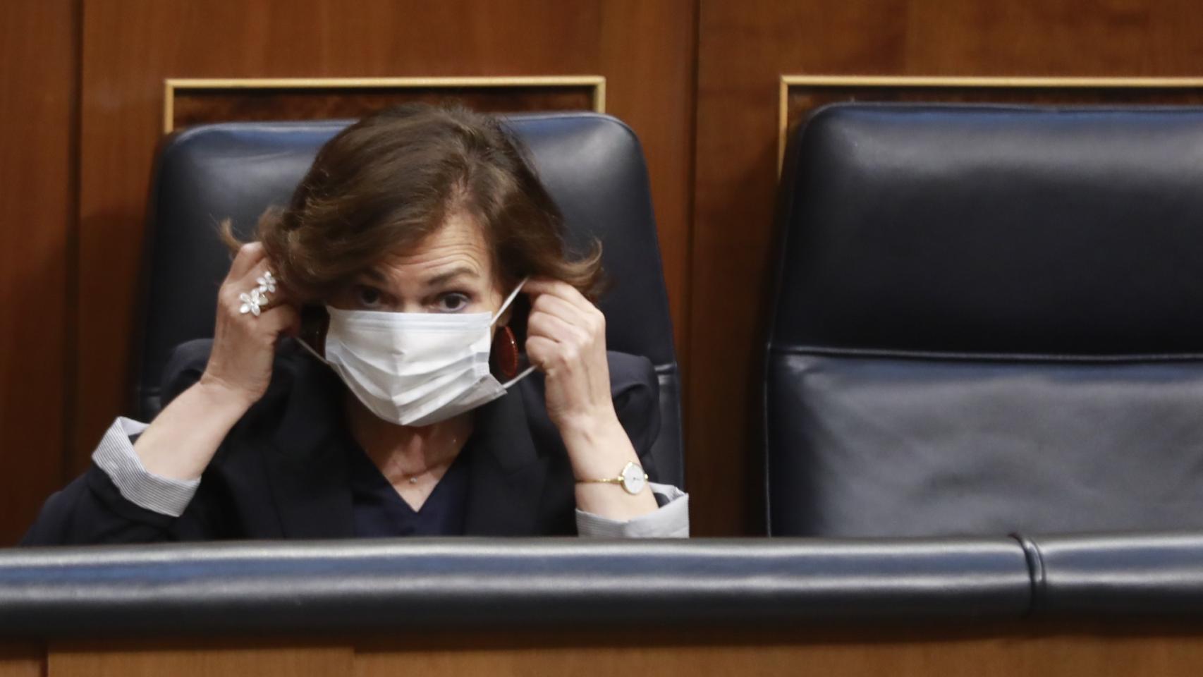 La vicepresidenta primera del Gobierno, Carmen Calvo, se coloca la mascarilla.