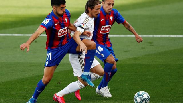 Dos jugadores del Eibar intentan robar el balón a Luka Modric
