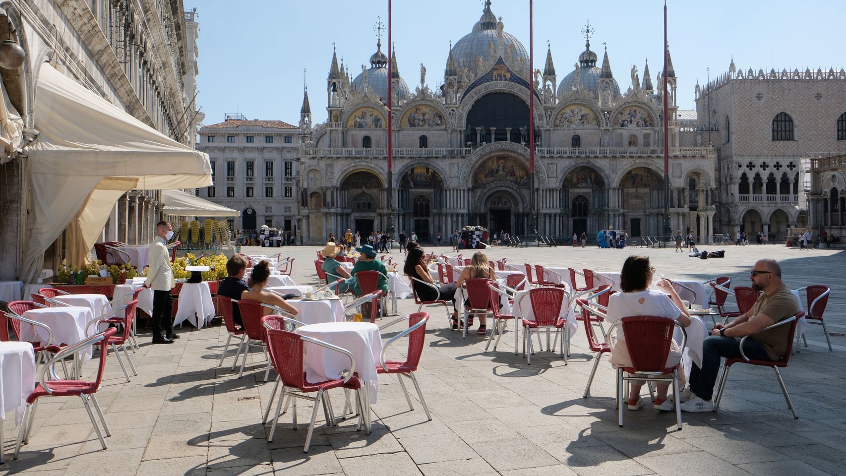 Algunas personas disfrutan de un café frente a la Plaza de San Marcos, en Venecia.