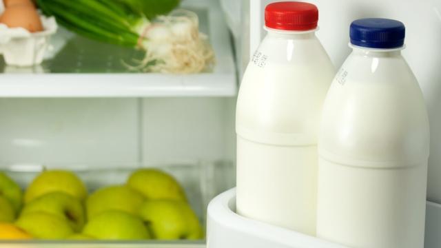 Unas botellas de leche en la puerta de la nevera