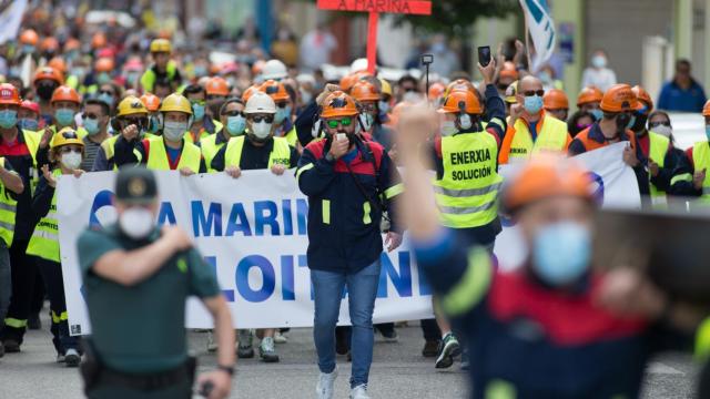 Trabajadores de Alcoa caminan por la calle con una pancarta en la que se lee 'A Mariña Sálvase Loitando'.