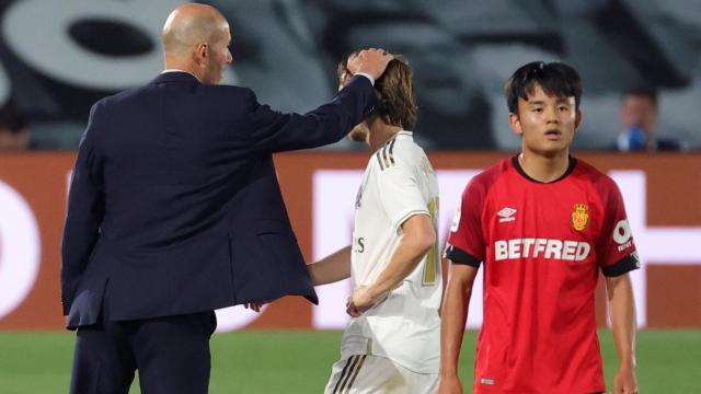 Zinedine Zidane felicita a Luka Modric por su partido mientras pasa al lado Take Kubo