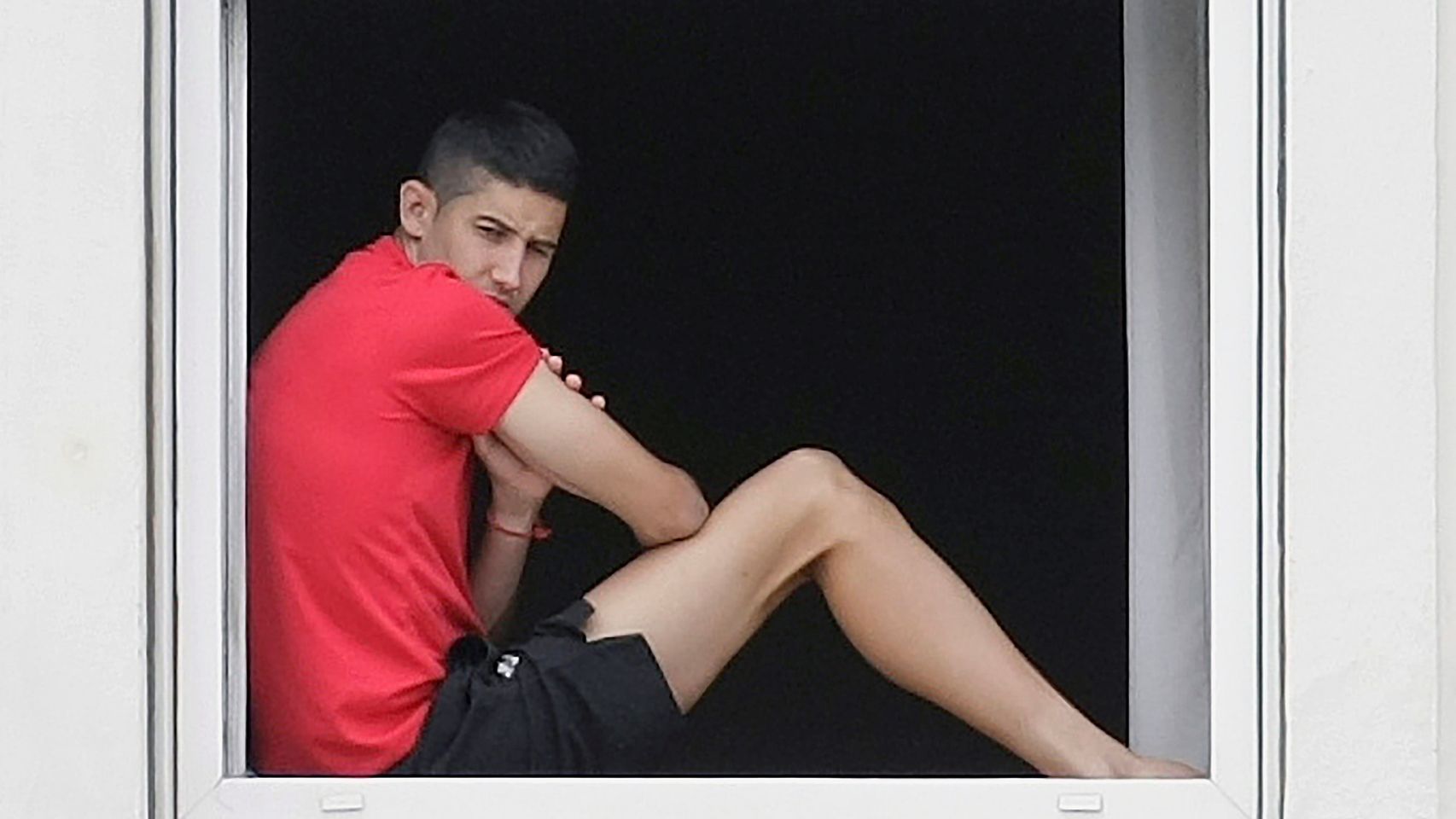 Jugador del CF Fuenlabrada en la ventana de hotel donde están confinados