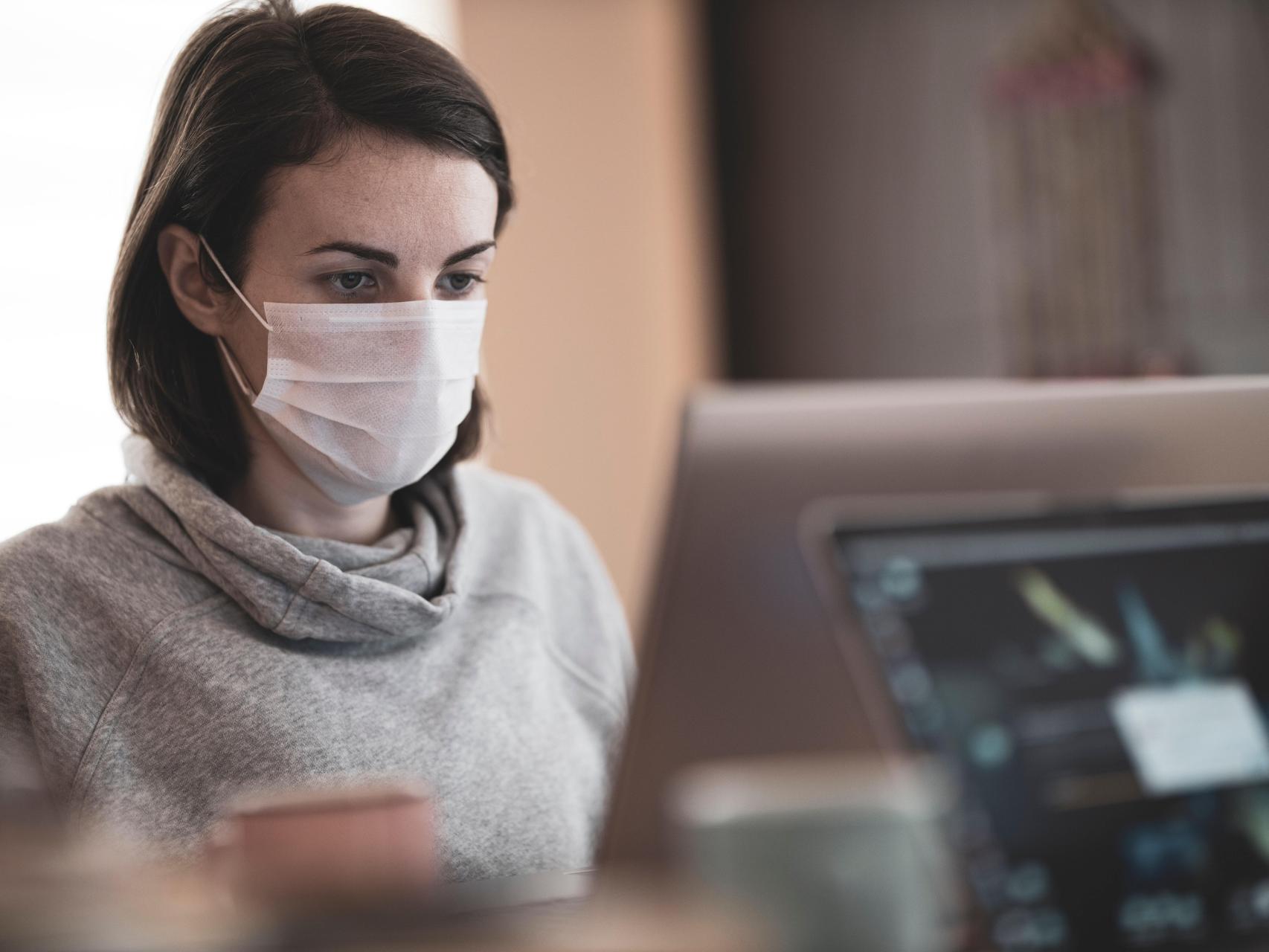 Una mujer con mascarilla en su puesto de trabajo, en una imagen de archivo.