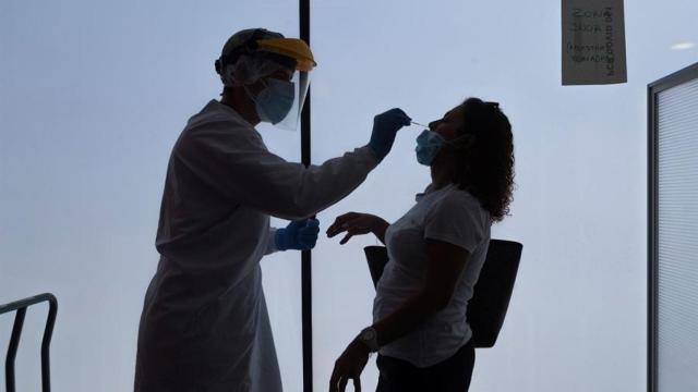 Un sanitario realiza una prueba PCR a una joven.