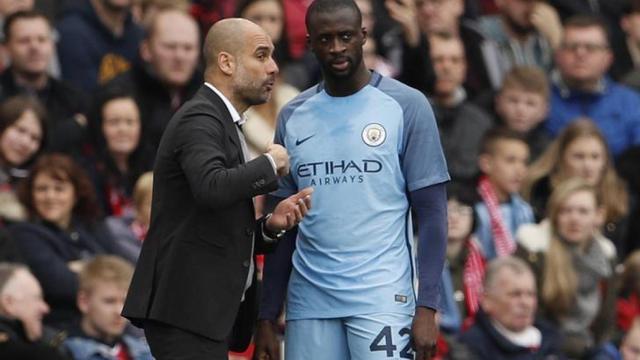 Yaya Touré y Guardiola conversan durante un partido del Manchester City