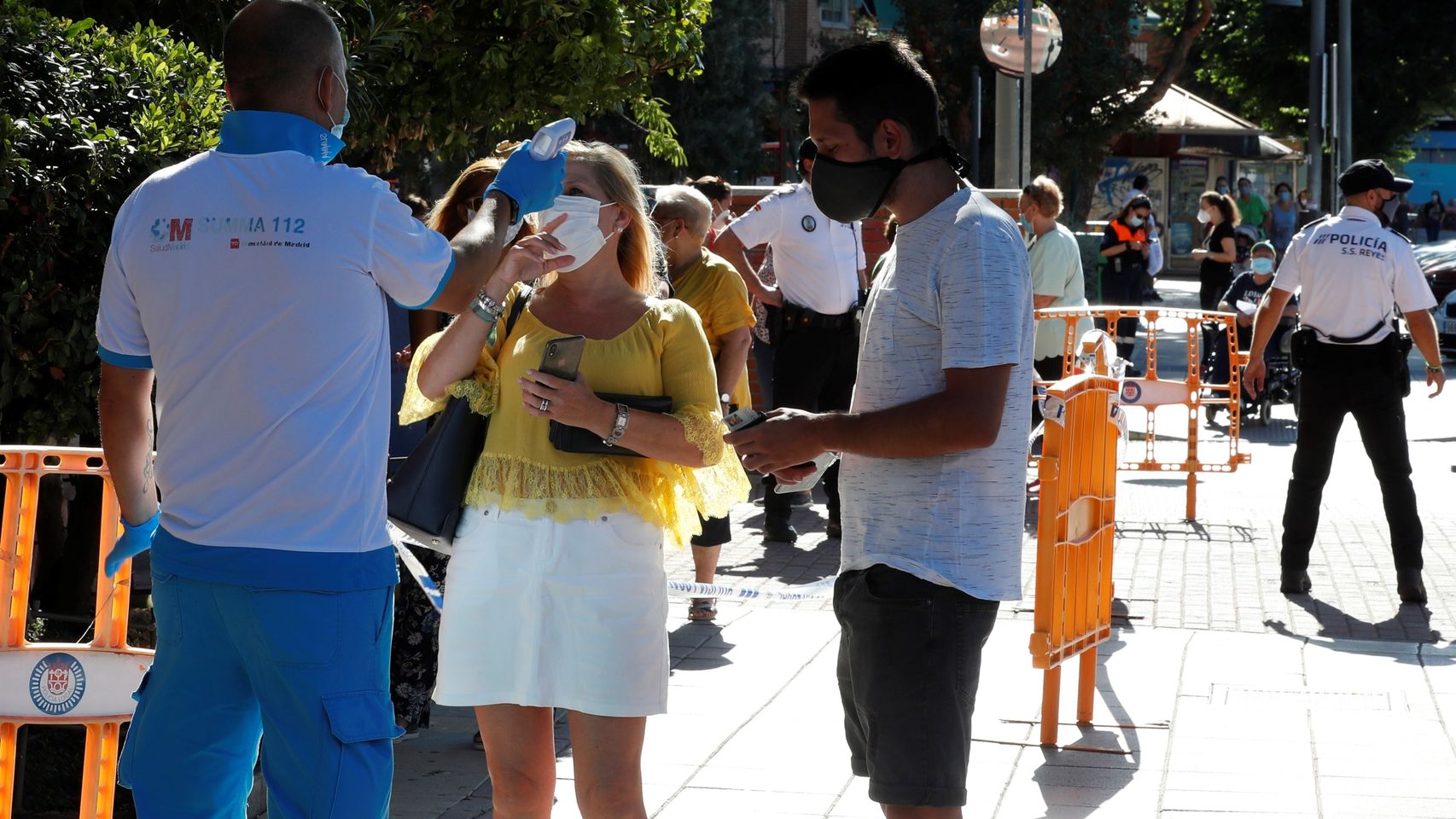 Un paramédico toma la temperatura a un mujer antes de acceder al centro de salud Reyes Católicos.