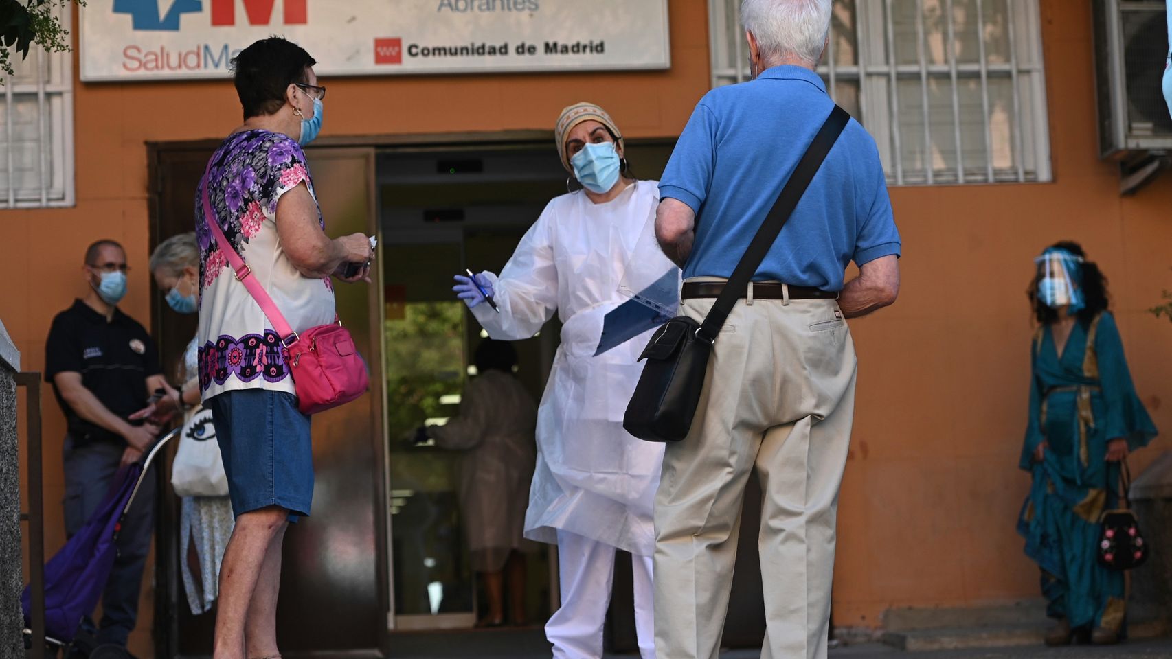 Varias personas esperan su turno para las pruebas aleatorias de PCR en el distrito de Carabanchel, en Madrid.