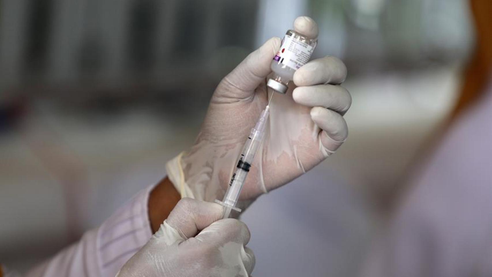 Un sanitario manipula una vacuna.