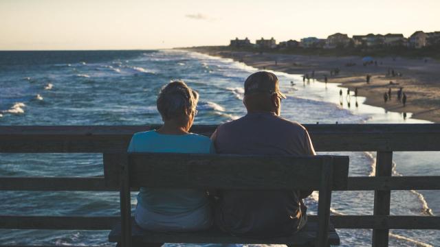 Una pareja de jubilados observando un atardecer.