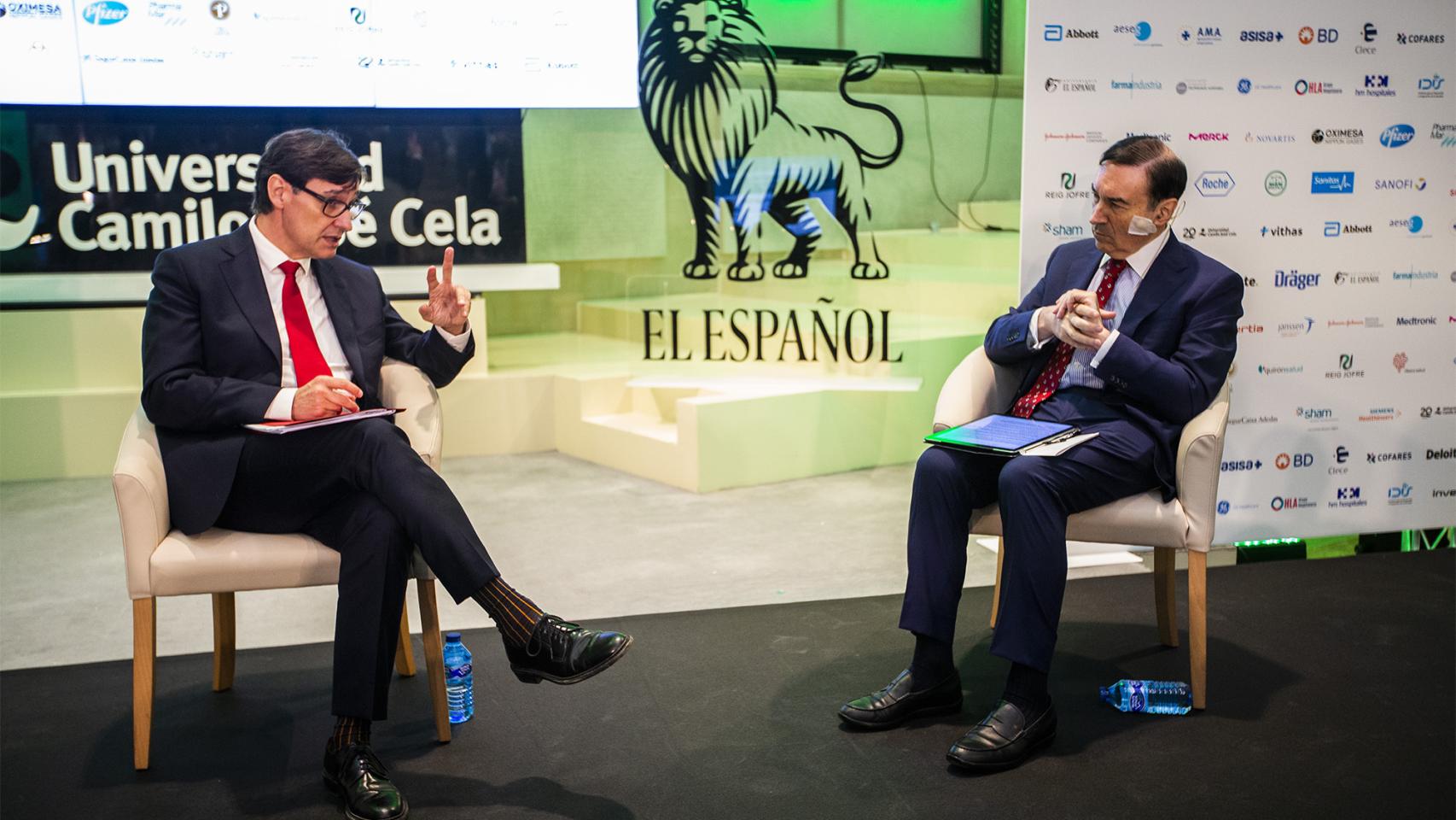 El ministro de Sanidad, Salvador Illa, conversa con el presidente ejecutivo y director de EL ESPAÑOL, Pedro J. Ramírez, durante la inauguración del simposio.