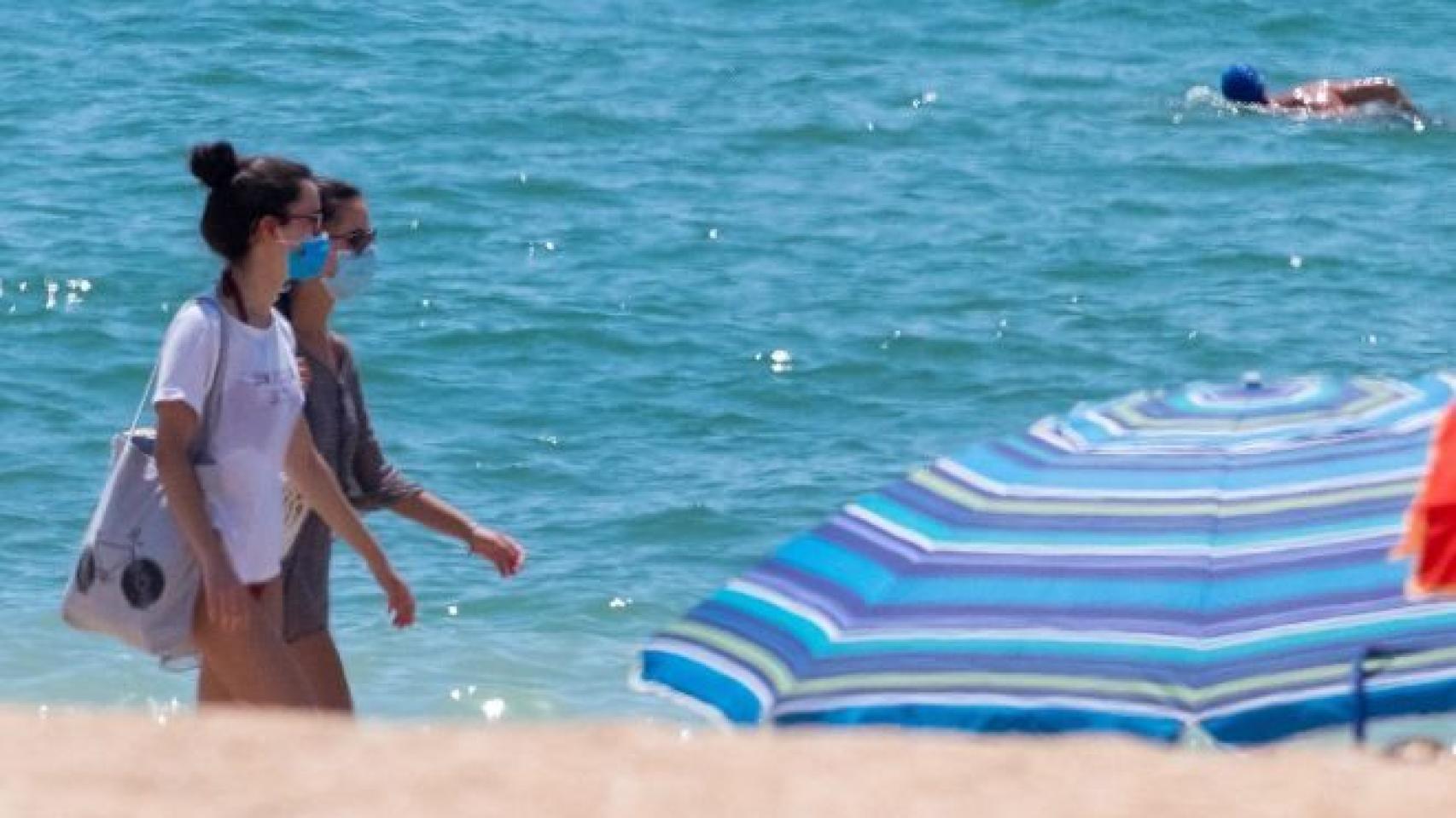 Dos mujeres pasean por la playa.