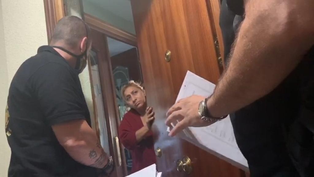 Rosa, la cuidadora de la difunta Pilar en la entrada de la casa okupada, y dos trabajadores de Desokupa.