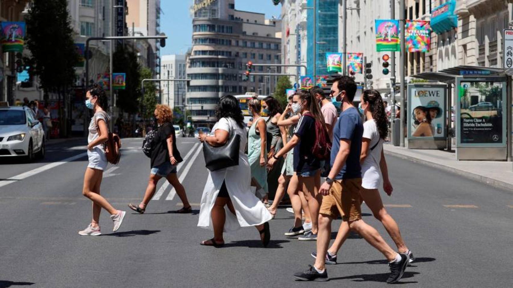 Un grupo de personas con mascarilla en Gran Vía.