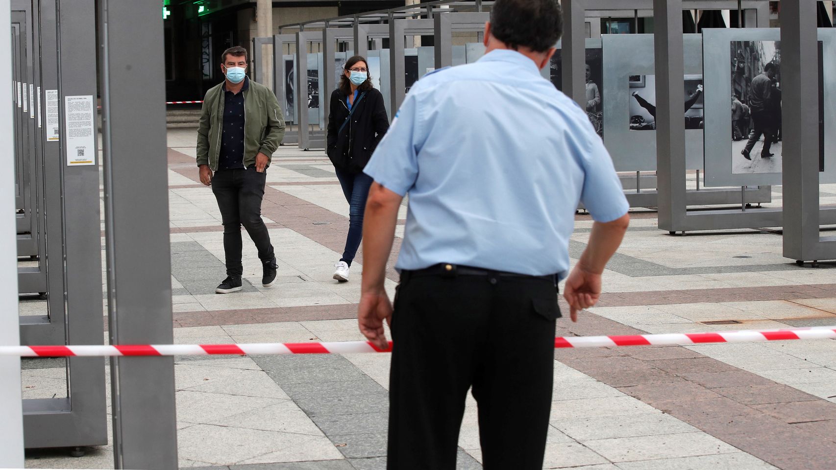 Un vigilante de seguridad conversa con un hombre y una mujer este sábado en Alcobendas.