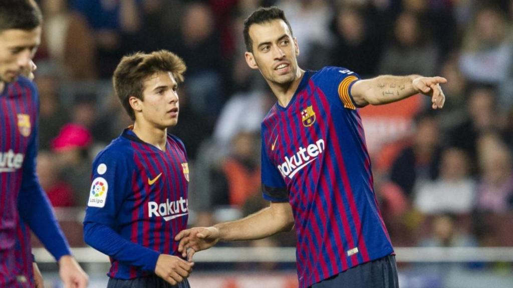 El debutante Riqui Puig recibiendo indicaciones de Sergio Busquets