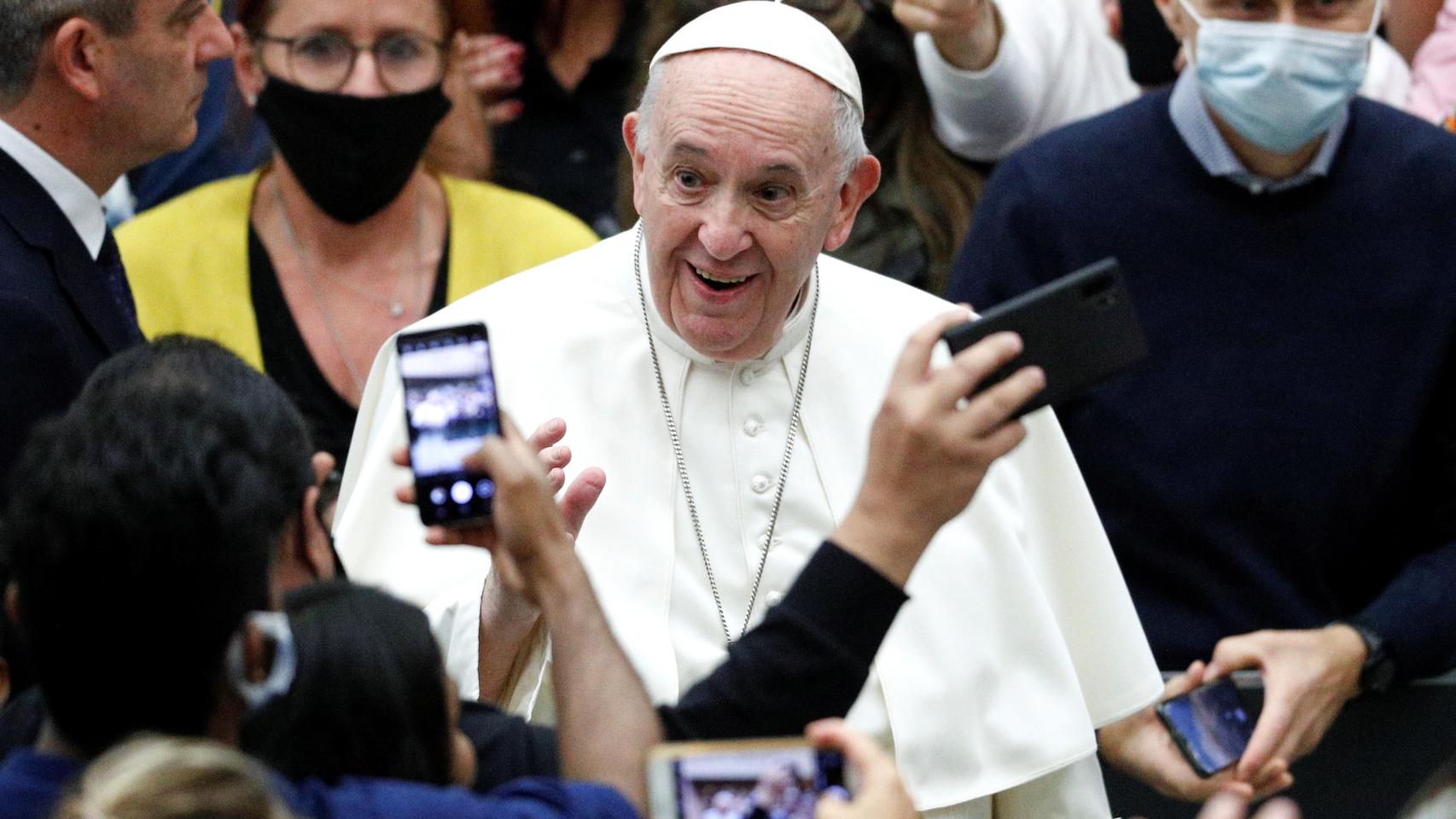 El papa, sin mascarilla, rodeado de fieles que sí la llevan.
