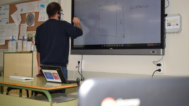 Un profesor con una pizarra digital.