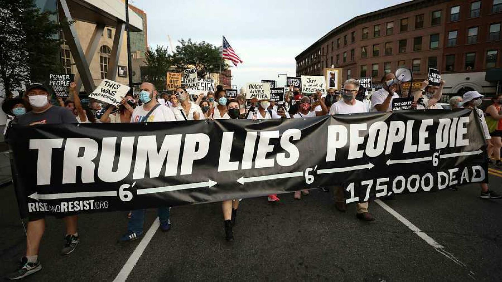 Personas marchan a la vigilia por las víctimas de la pandemia de coronavirus en Brooklyn, en agosto, con una pancarta que dice Trump miente, la gente muere.