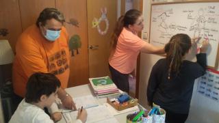 Román, y su mujer, María, dando clase a sus hijos en su casa de Las Torres de Cotillas (Murcia).