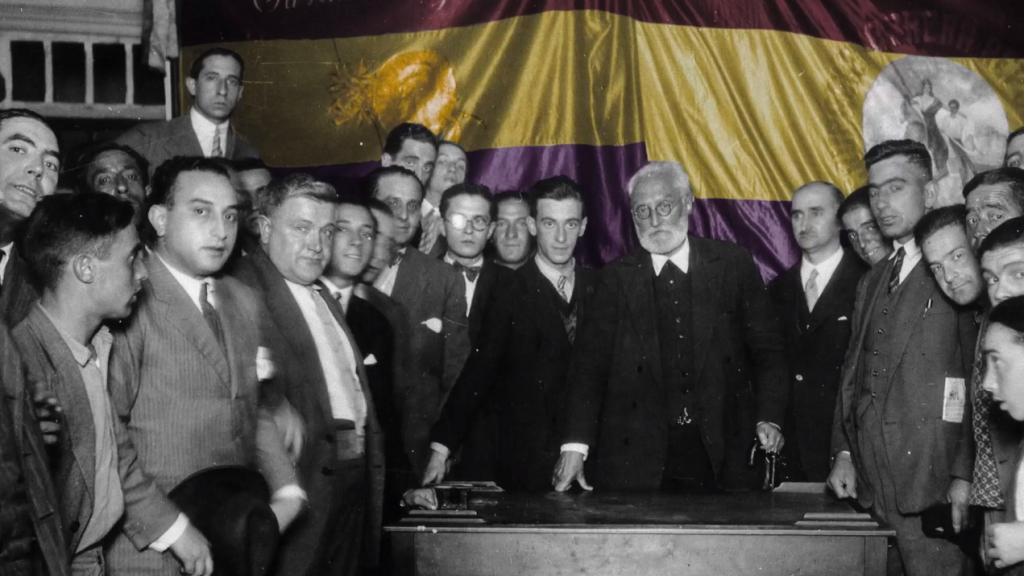 Miguel de Unamuno, en el centro, delante de una bandera republicana.