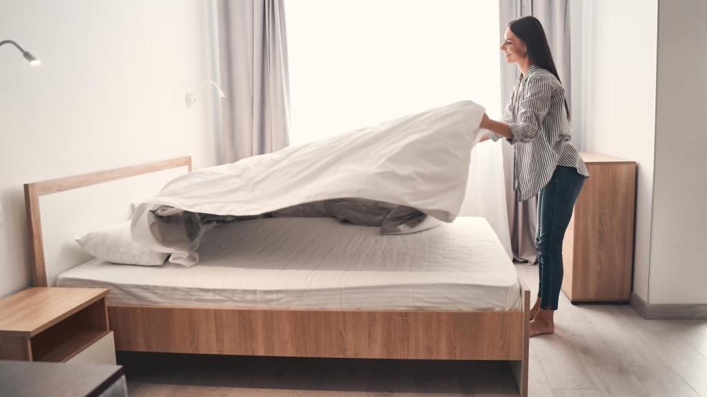 Una mujer haciendo la cama.