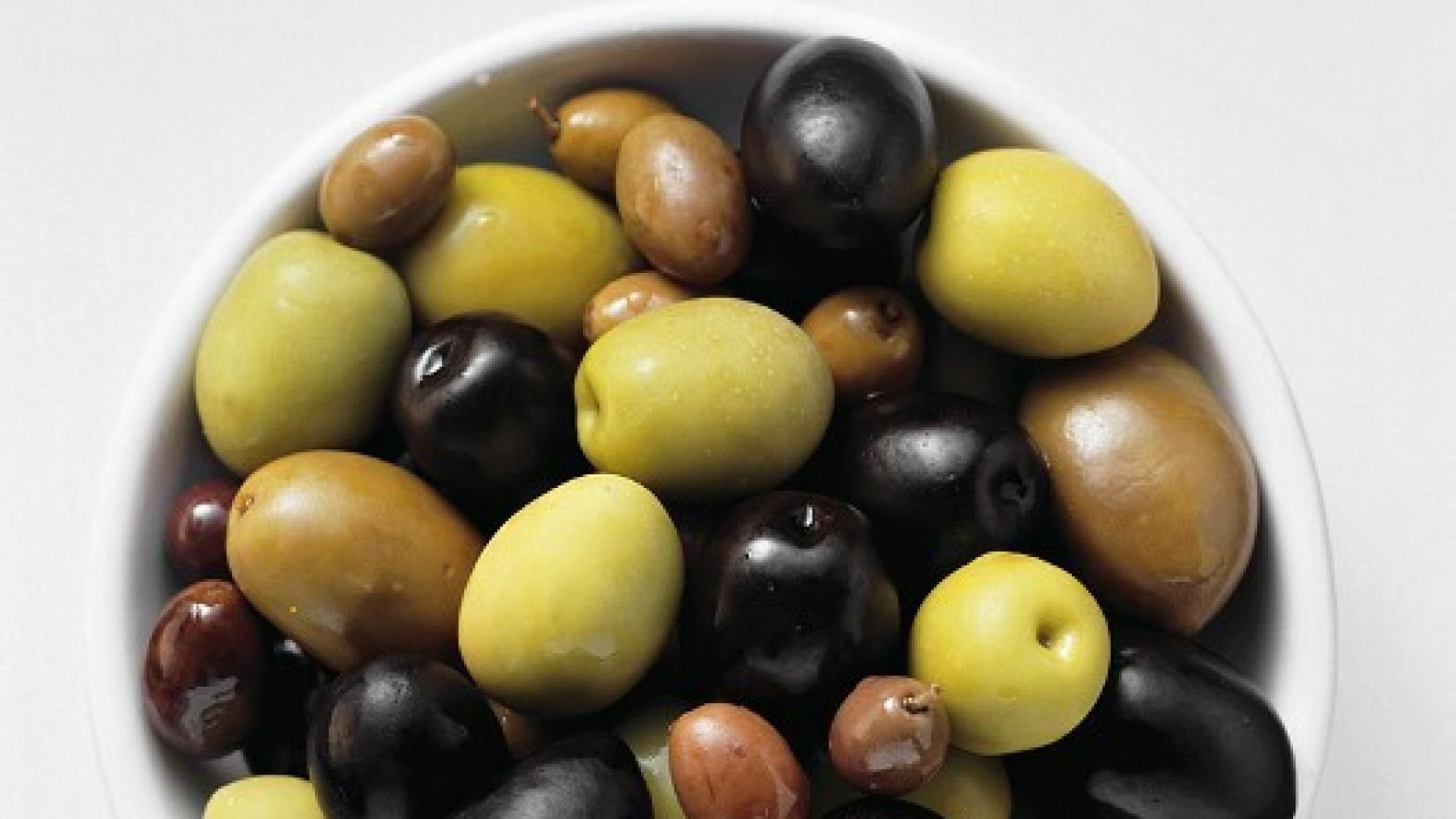 Un cuenco con aceitunas de todos los colores.