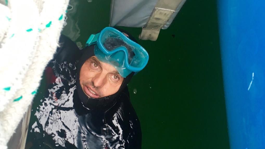 Didac Costa, a remojo, inspeccionando el casco.