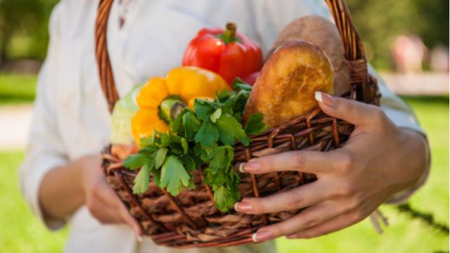 Una mujer sostiene verduras y hortalizas beneficiosas para la salud.
