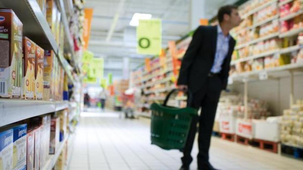 Un hombre mira las etiquetas en un supermercado.