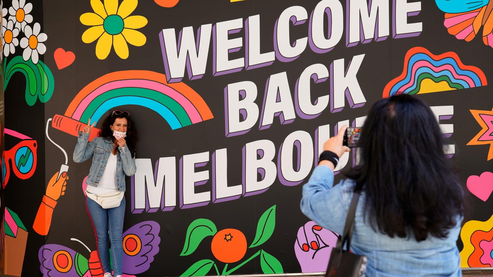 Una mujer toma una foto en el mural de 'Welcome Back', en Melbourne, Australia.