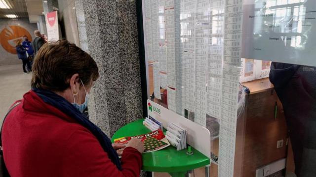 Una mujer jugando al 'rasca y gana'.