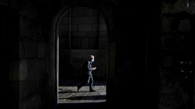 Un hombre con mascarilla camina  por el centro de La Coruña.