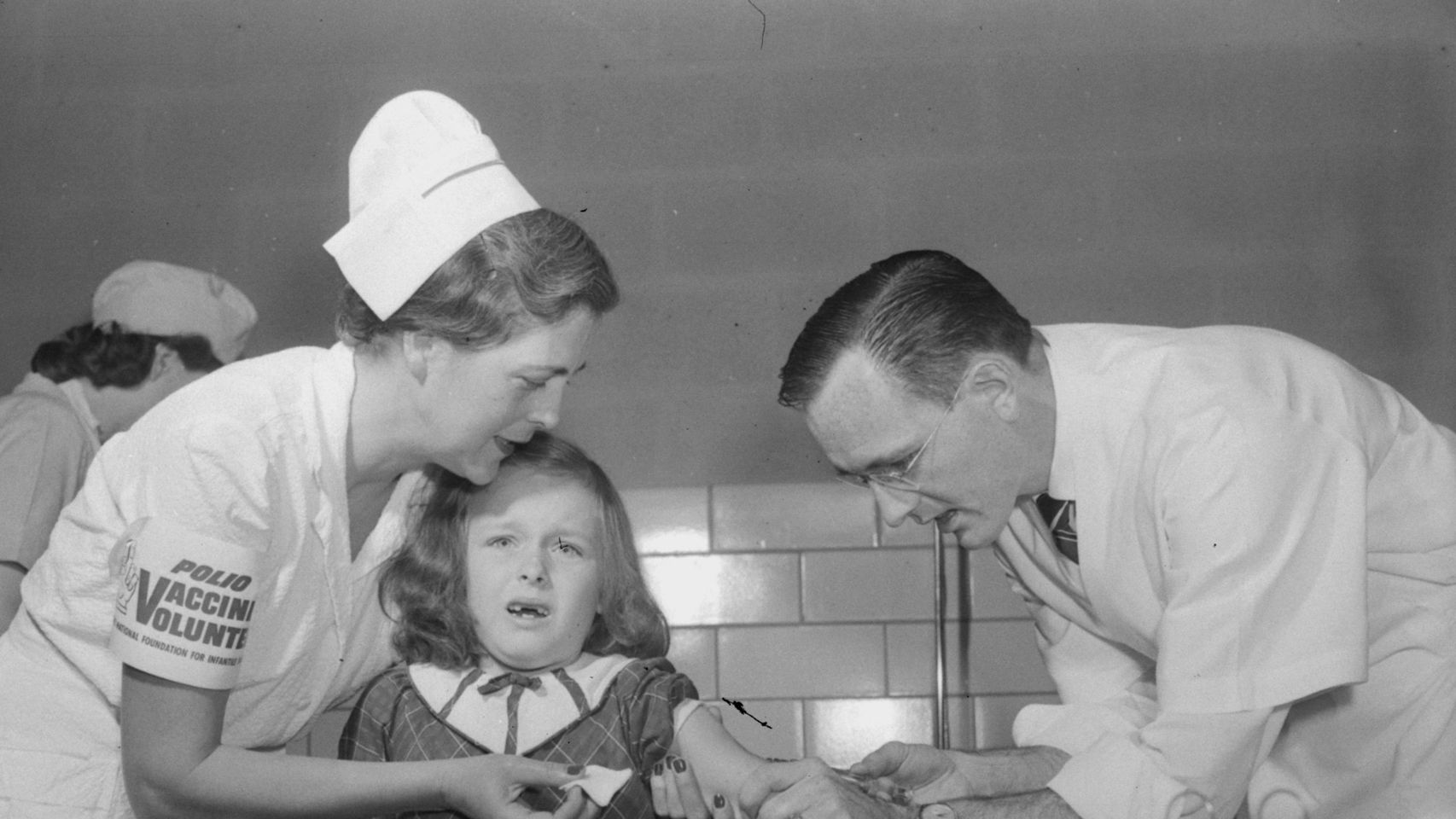 Una niña vacunándose de la polio.