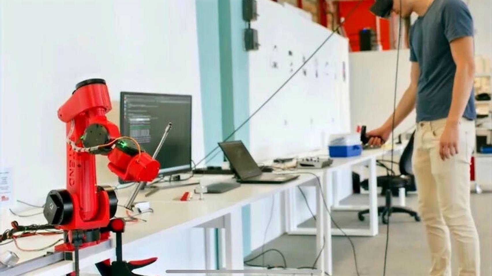 Un técnico manipula los componentes del brazo robótico, en primer plano.
