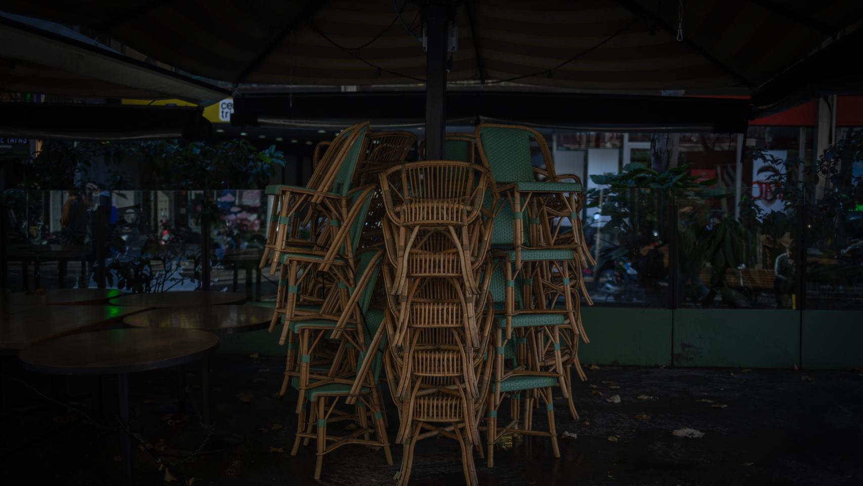 Varias sillas apiladas en una terraza.